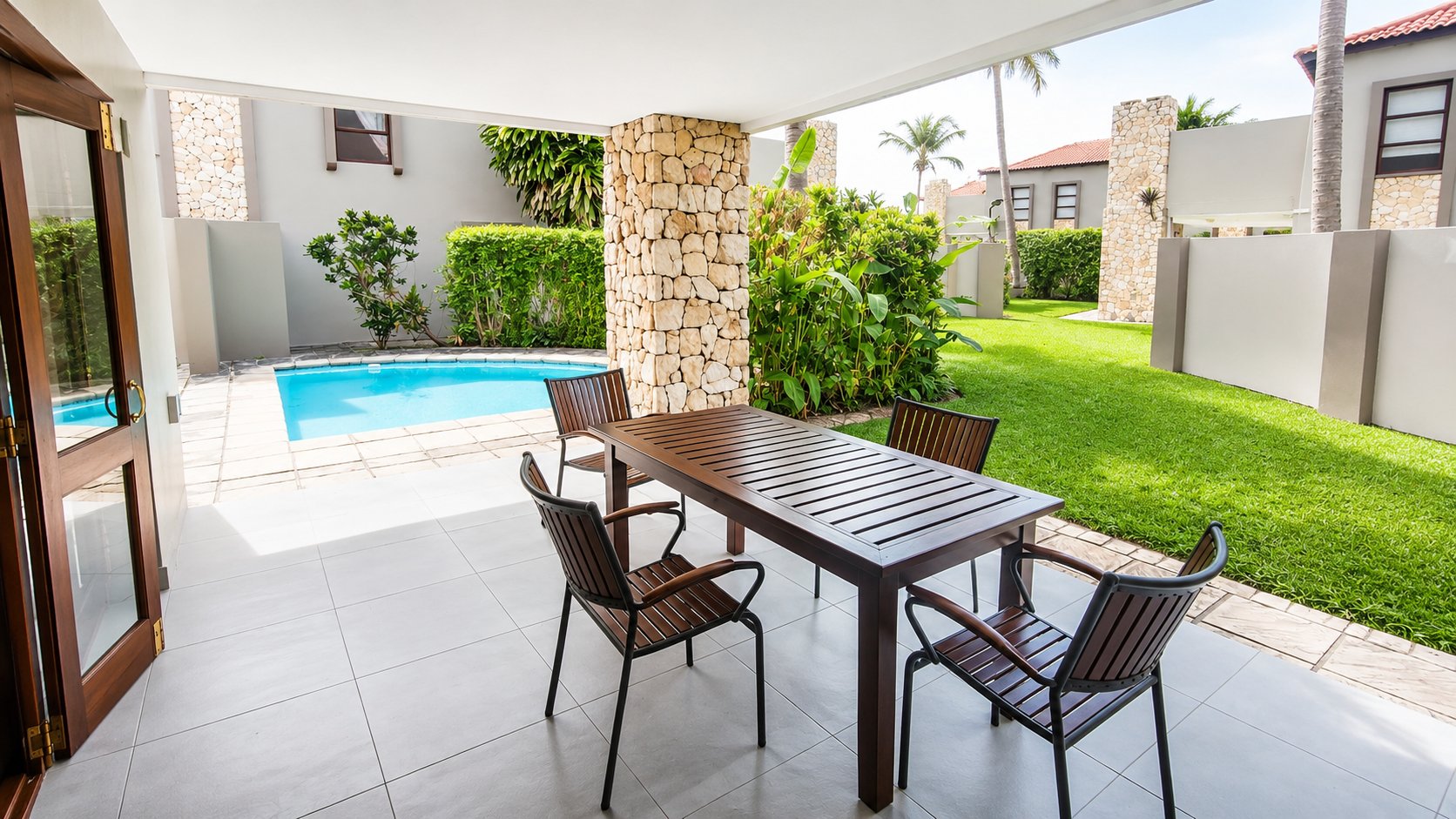 Covered patio with dining table beside the pool