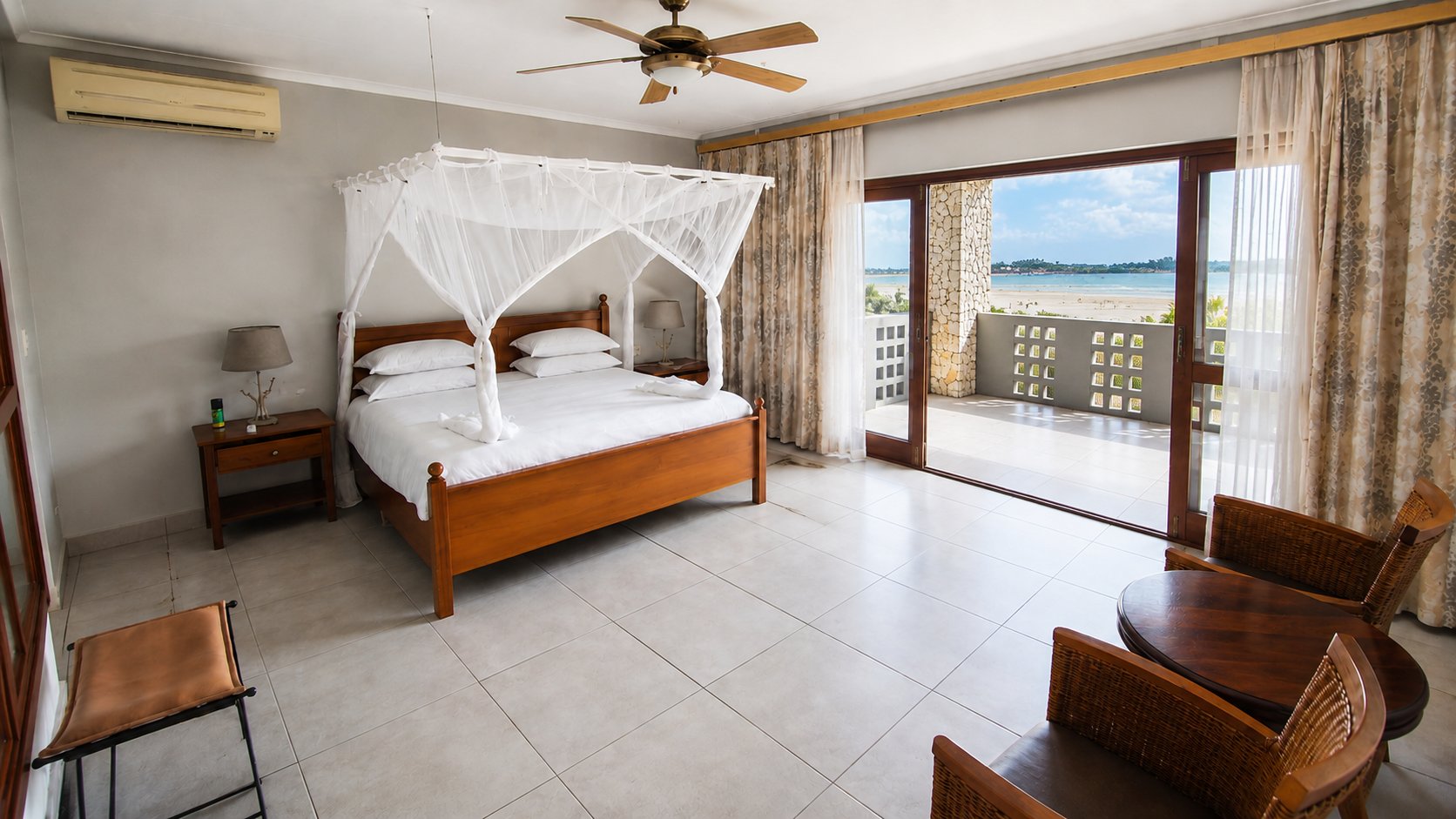 Beachfront bedroom with four-poster bed and ocean views