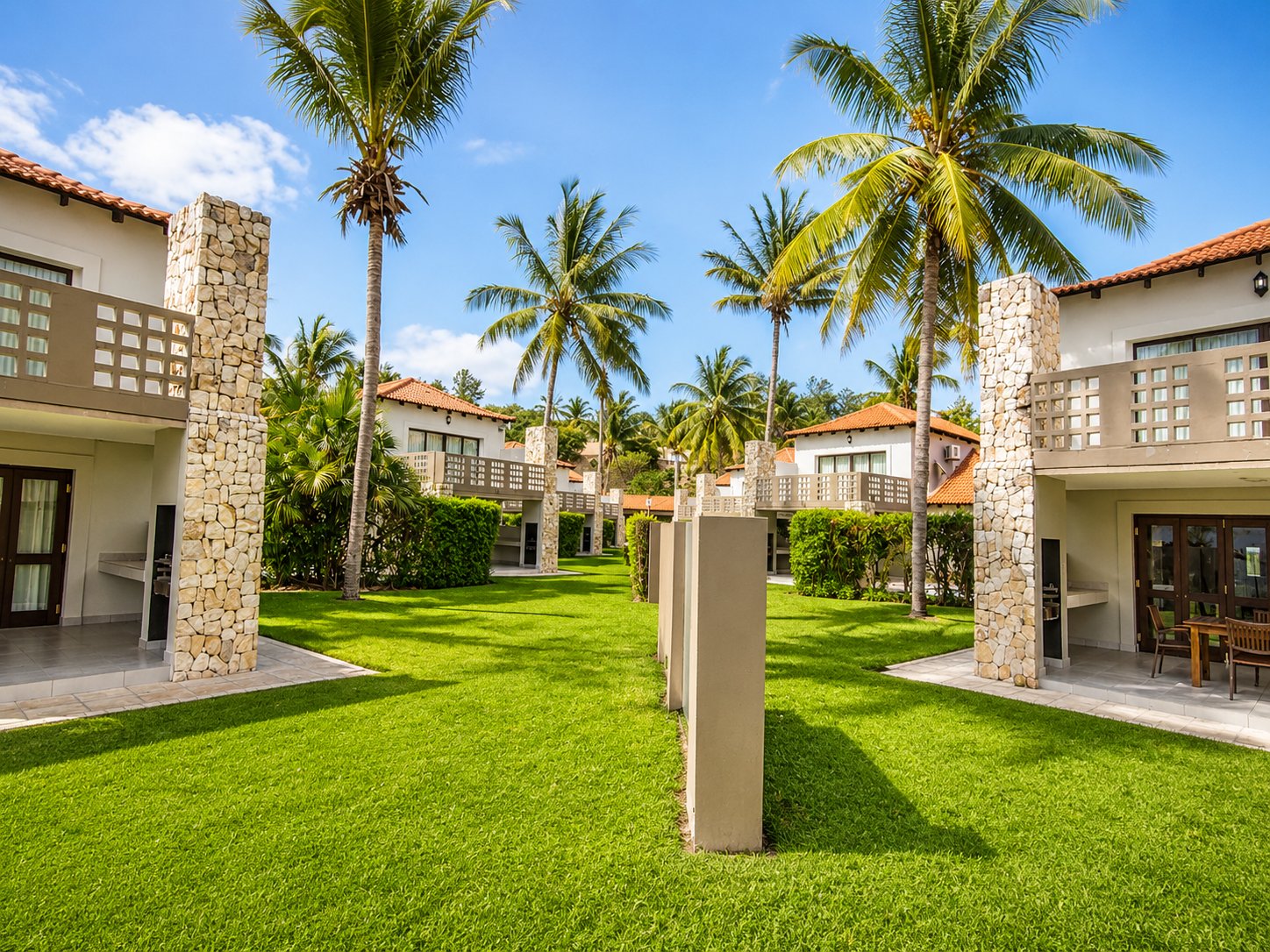 Palm-lined garden walkway between the units